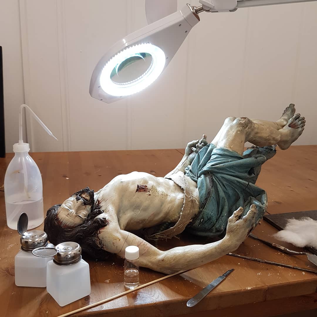 En mitad del proceso de restauración de una "Piedad" (aquí solo el Cristo) tallada en madera de cerezo.